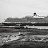 HippyfromOz > Tuesday 26 February 2008 - Today,  Cunard’s new ocean liner, Queen Victoria, visited Brisbane on her maiden voyage.
Unfortunately she couldn't dock at Portside Wharf because of her size.  The ship was forced to berth at the grain terminal at Fisherman's Wharf.  The public were allowed to view the ship from Luggage Point on the opposite side of the river - you can see in the photo what the conditions were like.  I drove down there after work - it was raining, some cars were bogged, I managed to find a place to park and walked in the rain through mud and slush till I found a grassy patch and took a photo from there.  Apart from the fact that my camera was wet, I was scared I was going to slip over.  I wan't brave enough to venture any closer. Have come to the decision that I need to be certified.
Not a good photo but it's all I got.