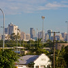 HippyfromOz > Friday 4 April 2008 - I know - a strange sort of photo for me to post - this was taken from the car & is a scene I see every working day - this morning it was a bit hazy.  I drive into Brisbane in crazy traffic through all the eastern suburbs, until I get to this intersection on top of a small hill, where I stop waiting to turn right.  This is the first time I can see the CBD and for some reason, when I see this view I always evaluate what on earth I am actually doing on this merry-go-round of life.  I live outside the city for a reason - I am not a citygirl, and yet I work there - how crazy is that !!! The beige colour building in the foreground on the right is where I work.  The high lights on the right hand side belong to Langlands Park, a football field attached to my workplace.  The little white building is some sort of electrical sub station.